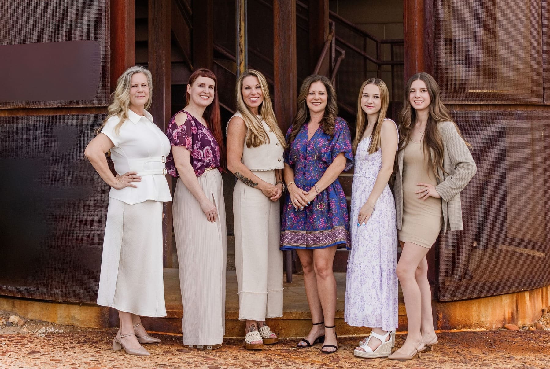 Six women from the Kitchens by Goods Guys team in Scottsdale, Arizona, smiling together outdoors